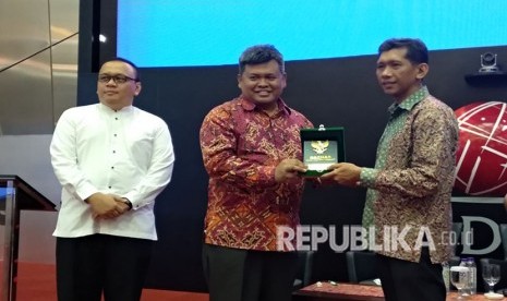 Deputi Badan Amil Zakat Nasional (Baznas) Arifin Purwakananta (tengah), Direksi PT Henan Putihrai Mohamad Yunus (ujung kanan), dan Dewan Syariah Nasional Irfan Syauqi Beik (ujung kiri) meresmikan pembukan 36 gerai zakat saham di sejumlah mall dan perkantoran yang dibuka hingga akhir Ramadhan 2018 di Bursa Efek Indonesia (BEI), Jumat (11/5). 