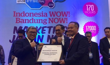 Deputi Direksi BPJS Kesehatan Wilayah Jabar Mohammad Edison (kanan) disaksikan Gubernur Jabar Ahmad Heryawan (kiri) menerima award sebagai Industry Marketing Champion Bandung 2018 dalam ajang penghargaan Industry Marketing Champion dan Marketeer of The Year Bandung 2018 di Grand Mercure Hotel, Kota Bandung, Kamis (19/4).