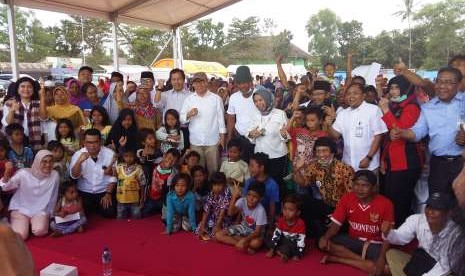 Deputi Gubernur Bank Indonesia (BI) Rosmaya Hadi (tengah berjilbab) berfoto bersama anak-anak di posko pengungsian korban gempa Lombok, di Desa Gondang, Kecamatan Gangga, Kabupaten Lombok Utara, Nusa Tenggara Barat, usai memberikan bantuan, Kamis (16/8).