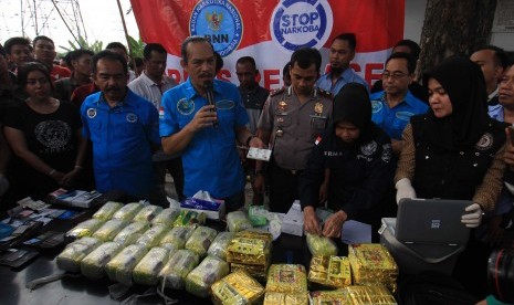 Deputi Pemberantasan Badan Narkotika Nasional (BNN) BNN Irjen Pol Arman Depari (tengah) memperlihatkan barang bukti narkoba setelah berhasil menangkap bandar narkoba di Jalan AH Nasution Medan, Sumatera Utara, Selasa (20/3).