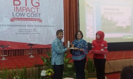 Deputy GM Wilayah Indonesia Barat JNE Hasmeliyani Suseno (tengah) memberikan cinderamata kepada Ketua Hipmi Kabupaten Bandung Andri Juwandi dalam acara seminar UMKM di Hotel Puri Khatulistiwa, Sumedang, Selasa (20/12).