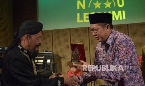 Menag Lukman Hakim Saifuddin menerima Anugerah Saptawirakrama dari Ketua LESBUMI PBNU Agus Sayoto (kiri) di Jakarta, Kamis (24/3).