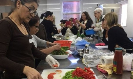 Di dapur Sinagoga Emanuel, para perempuan tertawa, bernyanyi dan berbagi cerita.