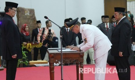 Di hadapan Mendagri Tjahjo Kumolo (kiri) dan Gubernur Jawa Barat Masa Jabarat 2013-2018 Ahmad Heryawan, Komjen Pol Mochamad Iriawan menandatangani jabatan Penjabat Gubernur Jawa Barat, di Gedung Merdeka, Kota Bandung, Senin (18/6).