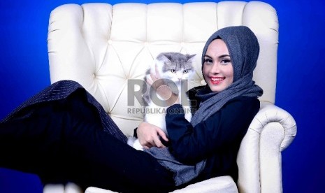 Muslimah menggendong kucing peliharaannya. 