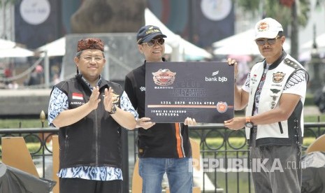 Didampingi Gubernur Jabar Ahmad Heryawan (kanan), Dirut Bank BJB Ahmad Irfan (tengah) dan Ketua Umum Harley Davidson Club Indonesia (HDCI) Nanan Soekarna memegang mock up Kartu Co-Branding Bank BJB usai penandatangan kerjasama HDCI pada acara International Bandung Week Bike Week 2017 di sela- sela Semarak Pesta Rakyat HUT Provinsi Jabar ke-72, di depan Gedung Sate, Kota Bandung, Sabtu (30/9).