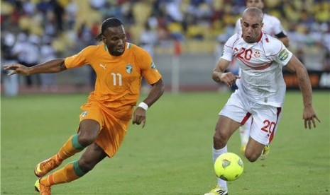 Didier Drogba (kiri), striker timnas Pantai Gading, berebut bola dengan pemain timnas Tunisia, Aymen Abdennour, di laga Grup D Piala Afrika 2013 di Rustenburg pada 26 Januari. 