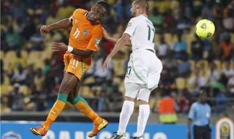 Didier Drogba (kiri), striker timnas Pantai Gading, duel udara dengan pemain Aljazair, Adlene Guedioura, di laga Grup D Piala Afrika 2013 di Rustenburg pada Rabu (30/1).