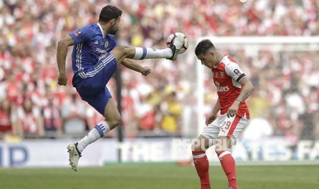 Diego Costa (kiri) berduel dengan  Granit Xhaka (kanan) pada pertandingan Final FA Cup di Webley Stadium, Inggris, Ahad (28/5) dini hari.