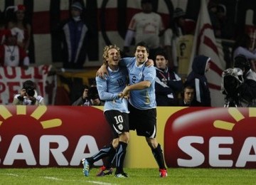 Diego Forlan dan Luis Suarez (kanan), dua striker andalan Uruguay, berpelukan usai Suarez mencetak gol ke jala Peru di babak semifinal Copa America 2011.