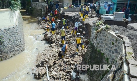 Dinas Pekerjaan Umum (DPU) Kota Bandung membereskan kirmir Sungai Cinambo yang ambrol, di Jalan AH Nasution, Kota Bandung, Senin (11/2).