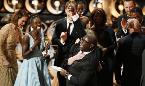 Director and producer Steve McQueen celebrates after accepting the Oscar for best picture with Lupita Nyong'o for 12 Years a Slave.