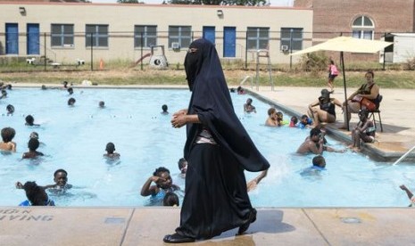 Direktur Akademi Darul-Amaanah Tahsiyn Ismaa'eel memperhatikan muridnya yang berenang di kolam renang Dr Foster M Brown Pool di Wilmington, Delaware, AS, 12 Juli 2018.