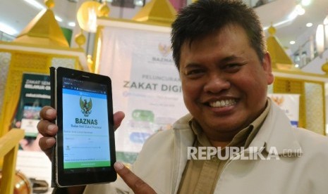 Direktur Amil Zakat Nasional BAZNAS Arifin Purwakananta, memperlihatkan web Zakat Digital pada peluncurannya di Jakarta, Jumat (24/6). (Republika/Darmawan)