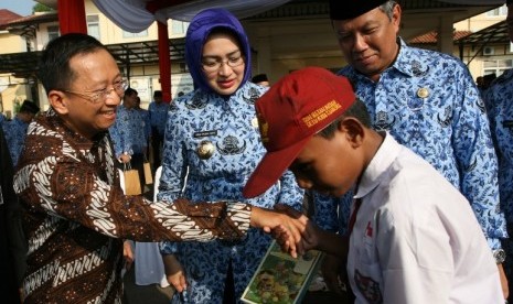 Direktur APP Suhendra Wiriadinata bersama Wali Kota Tangsel Airin Rachmi memberikan bantuan buku tulis kepada siswa SD di Lapangan Cilenggang, Tangsel (18/5).