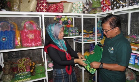  Direktur Bank Sampah Malang (BSM) Kartika Ikasari (kiri) menunjukkan produk hasil olah ulang dari sampah kepada Manajer Komunikasi Hukum dan Administrasi PT PLN Distribusi Jawa Timur, G Wisnu Yulianto, di Kantor BSM Malang, Senin (19/2)