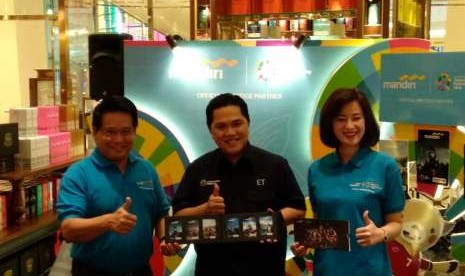 Direktur Bisnis Kecil dan Jaringan Bank Mandiri Hery Gunardi (kiri) dan Ketua Inasgoc Erick Thohir (tengah) berfoto menujukan kartu uang elektronik Bank Mandiri E-Money edisi khusus Energy of Asia untuk Asian Games 2018 di Mall Pacific Place, Rabu (15/8). 