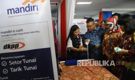 Direktur Commercial Banking Bank Mandiri Kartini Sally, Direktur Utama PT Dian Kencana Puri Prima (DKPP) Dian Hariani dan Direktur Digital Banking & Technology Bank Mandiri Rico Usthavia Frans (dari kanan) melakukan transaksi kepada agen usai peluncuran ke