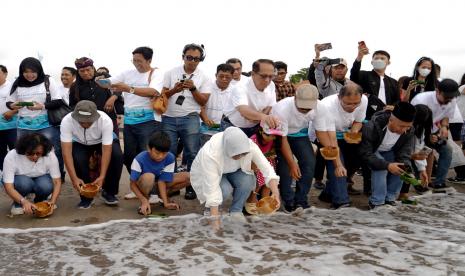 Direktur Compliance & Human Capital BSI Tribuana Tunggadewi (perempuan tengah) melepas 200 tukik bersama dengan masyarakat sekitar saat acara peluncuran BSI Sustainable Movement di Pantai Jerman, Badung, Bali.