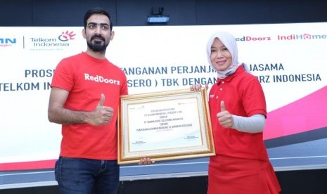 Direktur Consumer Service Telkom Siti Choiriana (kanan) bersama President Direktur RedDoorz Indonesia Mohit Gandas usai penandatanganan kerja sama dalam penyediaan layanan IndiHome dan infrastruktur Local Area Network (LAN) di seluruh jaringan mitra penginapan dan hotel yang berafiliasi dengan RedDoorz, di Jakarta, Rabu (25/9). 