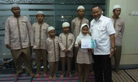 Direktur Eksekutif Baitulmaal Muamalat (BMM) Bambang Kusnadi menyerahkan santunan kepada anak-anak yatim dan dhuafa di kantor Bank Muamalat Cabang Kelapa Gading Jakarta,  Rabu (23/12).