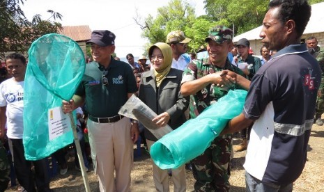 Direktur Human Capital Management PT PLN Muhamad Ali (kiri, bertopi) didampingi Direktur Medik dan Keperawatan RSCM Ratna Dwi Restuti (berjilbab) memberikan beragam bantuan kepada masyarakat Pulau Liran,  Kabupaten Maluku Barat Daya Rabu (20/9) lalu