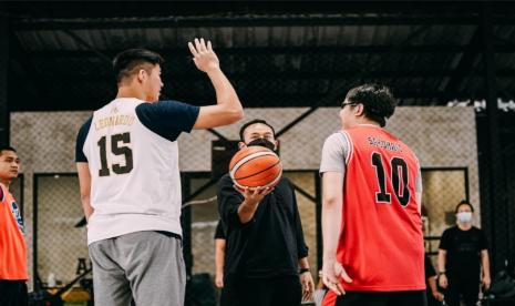 Direktur IBL Junas Miradiarsyah (tengah) melakukan tip-off pertandingan persahabatan tim yang diperkuat para pemain Dewa United Surabaya, personel IBL, dan wartawan peliput basket.