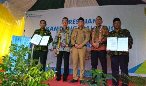 Direktur Kepesertaan BPJS Ketenagakerjaan (batik berkacamata) berdiri bersama Wakil Bupati Berau Kaltim Toni Tantomo (berpeci di tengah) saat peresmian Maluang sebagai desa sadar Jamsos pada Senin (1/7)