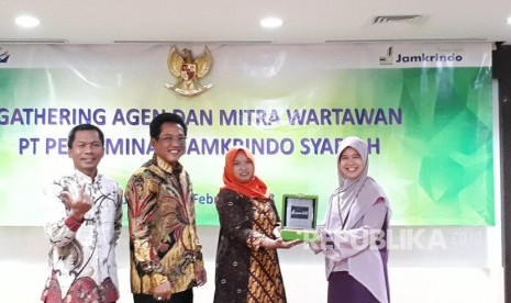 Direktur Keuangan Jamkrindo Syariah  Endang Sri Winarni (tengah) menyerahkan tanda apresiasi kepada perwakilan IKNB OJK Intan Herliana (kanan) didampingi Direktur Operasional Jamkrindo Syariah Achmad Sonhaji (kiri) dan Direktur Utama Jamkrindo Syariah Gatot Suprabowo (ke dua dari kiri) dalam silaturahim agen Jamkrindo Syariah dan media di Kantor Jamkrindo, Jakarta pada Kamis (15/2).