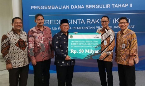  Direktur Komersial dan UMKM Bank BJB Agus Gunawan (kedua dari kanan) menyerahkan secara simbolik pengembalian dana KCR kepada Gubernur Jabar Ahmad Heryawan di Gedung Sate, Kota Bandung, Jumat (8/6).