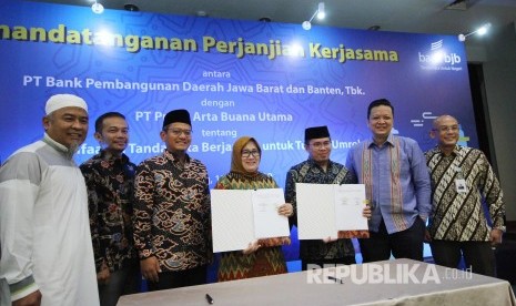 Direktur Konsumer Bank Bjb Suartini dan Dirut PT Praba Arta Buana Utama Afipuddien, memperlihatkan Perjanjian Kerjasama tentang Pemanfaatan Tandamata Berjangka Untuk Tujuan Umroh, di gedung Bank BJB, Jalan Naripan, Kota Bandung, Senin (15/4). 