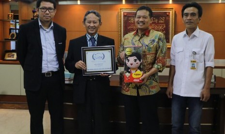 Direktur KUI Universitas AMIKOM Yogyakarta Erik Hadi Saputra dan Produser Eksekutif Battle of Surabaya Prof Suyanto (kedua dari kiri) menyerahkan penghargaan Best Animation Feature dari Hollywood International Moving Pictures Film Festival kepada Sekjen Kemendikbud Didik Suhardi yang didampingi Kepala Pusat Pengembangan Film Nasional Maman Wijaya. 