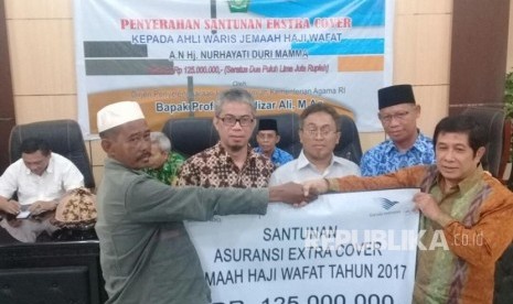  Direktur Layanan Haji Dalam Negeri Ahda Barori menyerahkan Santunan Ekstra Cover dari Garuda Indonesia kepada keluarga jamaah