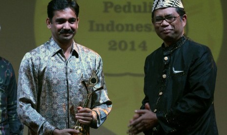 Direktur Marketing PT Tata Motors Distribusi Indonesia Pankaj Jain (kiri) menerima penghargaan The Best CSR katagori Informal Education Program Development dari Ketua Dewan Pembina Dompet Dhuafa Parni Hadi pada Charta Peduli Indonesia 2014 Dompet Dhuafa, d