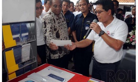 Direktur Micro & Retail Banking Bank Mandiri Hery Gunardi (kanan) memberikan penjelasan mengenai produk layanan keuangan mikro kepada Menteri Koordinator Bidang Kemaritiman Dwisuryo Indroyono Soesilo (kedua kanan) disaksikan oleh Ketua Dewan Komisioner OJK