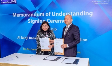  Direktur Operasional Bank BJB Fermiyanti (kiri) dan Chief Operating Officer (COO) Al Rajhi Bank Zarir Bin Mohd Rawi menunjukkan MoU yang ditandatanganinya di Ritz Carlton Pacific Place, Jakarta, Rabu (16/5).  