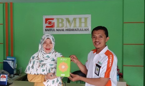 Direktur Operasional BMH DKI Jakarta, Rama Wijaya (kanan) dan CEO PT Khazanah Mimbar Plus, Yayah Rokayah Ramdan, memegang Alquran untuk program Sedekah Sejuta Alquran.