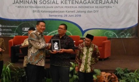 Direktur Pelayanan BPJS Ketenagakerjaan Krishna Syarif memberikan kenang-kenangan kepada pemerhati jaminan sosial Timboel Siregar dalam sebuah sarasehan di Semarang, Jawa Tengah, Kamis (27/6).