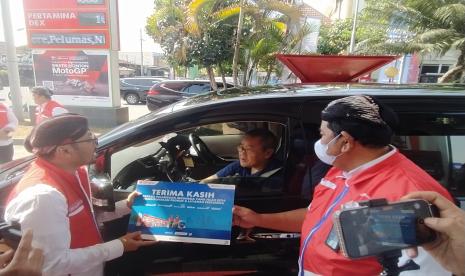 Direktur Pemasaran Regional Pertamina Patra Niaga, Mars Ega Legowo Putra (kiri) memberikan souvenir dan e-voucher BBK bagi konsumen yang menggunakan bahan bakar berkualitas dan ramah lingkungan serta bertransaksi secara cashless menggunakan aplikasi MyPertamina pada kegiatan sapa pelanggan di SPBU 41.552.02 Tegalrejo, Yogyakarta, Senin (4/9/2023). 