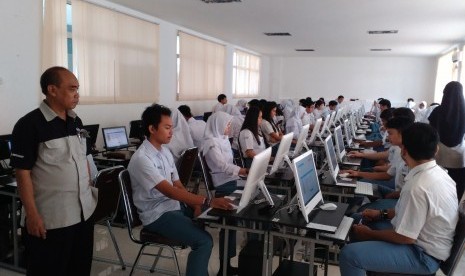 Direktur Pendidikan Sekolah Bosowa Bina Insani (SBBI) Sudirman (kiri) mengawasi siswa kelas XII SMA BBI yang tengah mengikuti simulasi Ujian Nasional Berbasis Komputer (UNBK), Senin (20/2/2017).