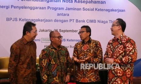 Direktur Perluasan Kepesertaan dan Hubungan antar Lembaga BPJS Ketenagakerjaan E Ilyas Lubis, Direktur Utama BPJS Ketenagakerjaan Agus Susanto, Presiden Direktur CIMB Niaga Tigor M. Siahaan dan Direktur Business Banking CIMB Niaga Rahardja Alimhamzah (kiri-kanan) berbincang usai acara Penandatanganan nota kesepahaman antara BPJS Ketenagakerjaan dengan CIMB Niaga dilakukan di Jakarta, Selasa (26/9).