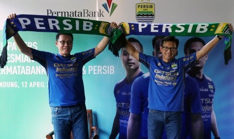 Direktur PermataBank Syariah Achmad K. Permana (kiri) bersama CEO Persib Bandung Bermartabat Teddy Tjahyono (kanan) mengangkat syal Persib pada acara Jumpa Pers kerjasama antara PermataBank Syariah dan Persib Bandung, Jawa Barat, Rabu (12/4). 