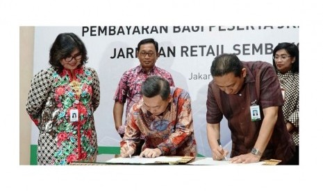 Direktur PT Bank Central Asia Tbk (BCA) Santoso (tengah) dan Direktur Keuangan & Investasi BPJS Kesehatan Kemal Imam Santoso (kanan) disaksikan oleh Direktur Perluasan & Pelayanan Peserta BPJS Kesehatan Andayani Budi Lestari (kiri) menandatangani Surat Edaran Bersama perihal Implementasi Layanan Autodebet BCA untuk Pembayaran Iuran Peserta Program Jaminan Kesehatan Nasional-Kartu Indonesia Sehat (JKN-KIS) di Jakarta, Rabu (18/04). 