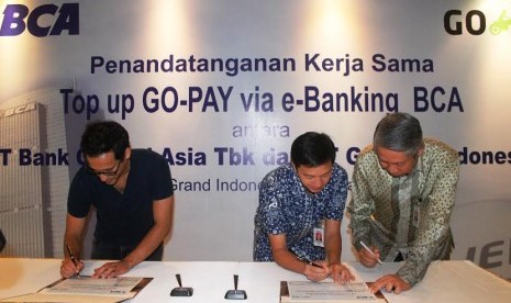 Direktur PT Bank Central Asia Tbk (BCA) Suwignyo Budiman (kanan), Direktur BCA Armand W. Hartono (tengah) dan CEO PT Gojek Indonesia Nadiem Makarim (kiri) menandatangani Perjanjian Kerja Sama yang menandai dukungan penuh BCA melalui fasilitas kemudahan Top