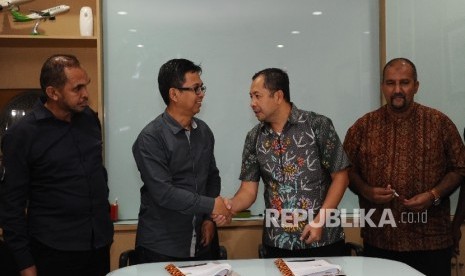 Direktur Republika Penerbit Arys Hilman Nugraha, (kedua kiri), Ketua Ikapi Hikmat Kurnia (kedua kanan) berjabat tangan usai melakukan penandatanganan kerjasama di kantor Harian Republika, Jakarta, Selasa (7/3).