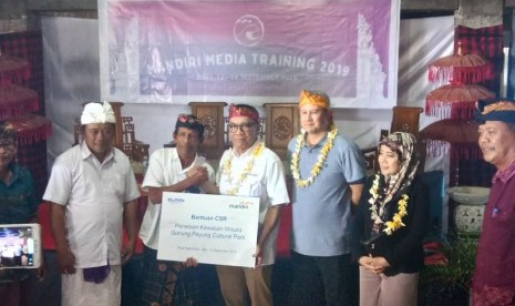 Direktur Retail Banking Bank Mandiri, Donsuwan Simatupang menyerahkan bantuan CSR di Desa Kutuh, Badung, Bali, Kamis (11/9).   