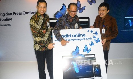 Direktur Retail Banking Bank Mandiri Tardi, Direktur Operations Ogi Prastomiyono , dan SEVP Chief Technology Officer Joseph Godong (dari kiri) menunjukan layanan Mandiri Online saat peluncuran mandiri Online di Jakarta.