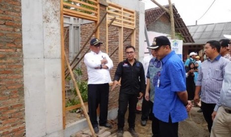 Direktur Rumah Khusus Ditjen Penyediaan Perumahan Kementerian PUPR Lukman Hakim (kiri) berbincang-bincang dengan Bupati Tangerang Ahmed Zaki Iskandar di depan salah satu rumah masyarakat yang dibangun dengan teknologi Rumah Instan sederhana .