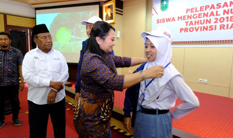 Direktur SDM dan Umum PT PGN Tbk Desima E. Siahaan memakaikan name tag dan topi ke perwakilan siswa peserta SMN sebagai simbolisasi pelepasan para siswa asal Riau ke Maluku, Senin (13/8).