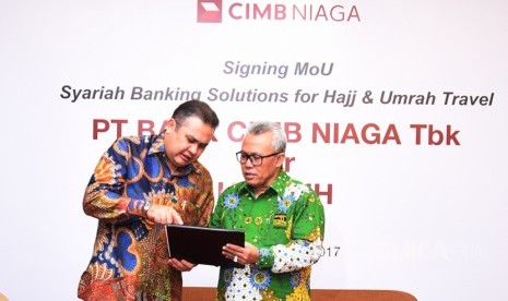 Direktur Syariah Banking CIMB Niaga Pandji P. Djajanegara (kiri) berbincang dengan Ketua Umum Himpunan Penyelenggara Umrah dan Haji Khusus (HIMPUH) H. Baluki Ahmad usai penandatanganan Memorandum of Understanding di Jakarta, Rabu (12/4).